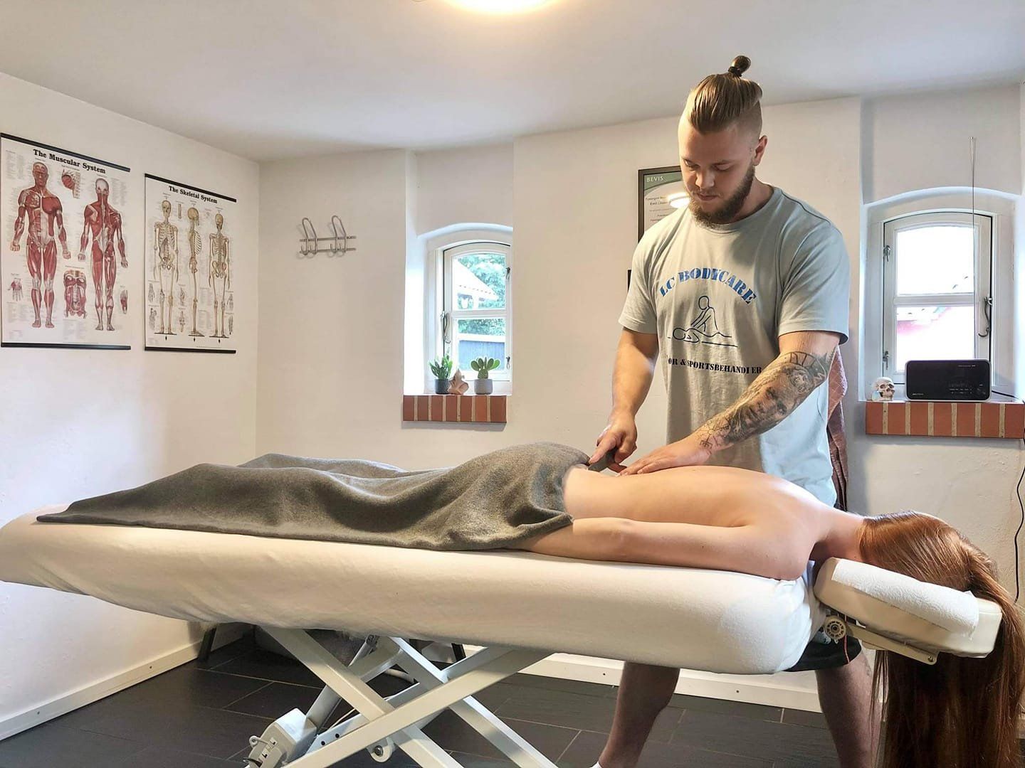 En mand giver en kvinde massage på et bord.