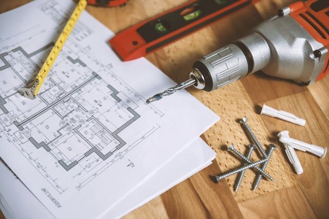 a drill and tape measurer on a blueprint