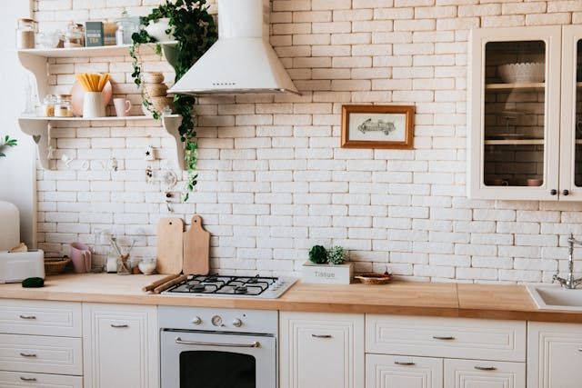 a kitchen with a brick wall and open shelving