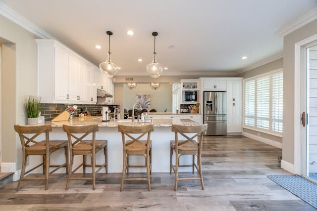a kitchen with white cabinets and granite counters