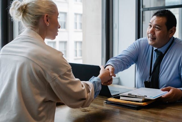 a landlord and tenant shaking hands after signing a contract)
