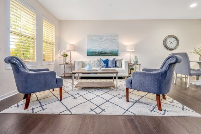a living room with a white couch and two blue armchairs