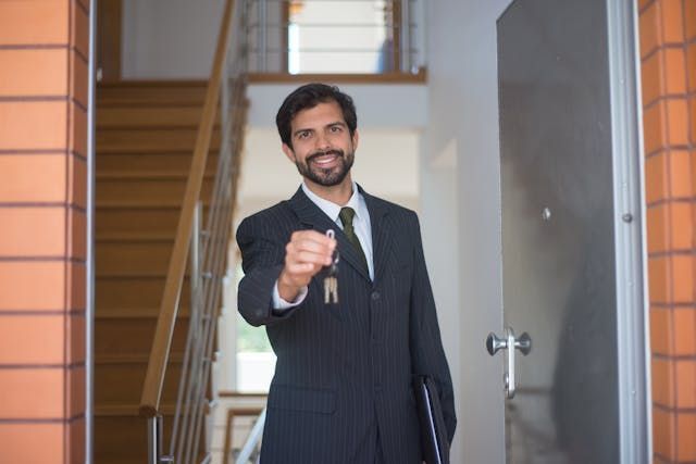 a property manager standing in a doorway holding keys