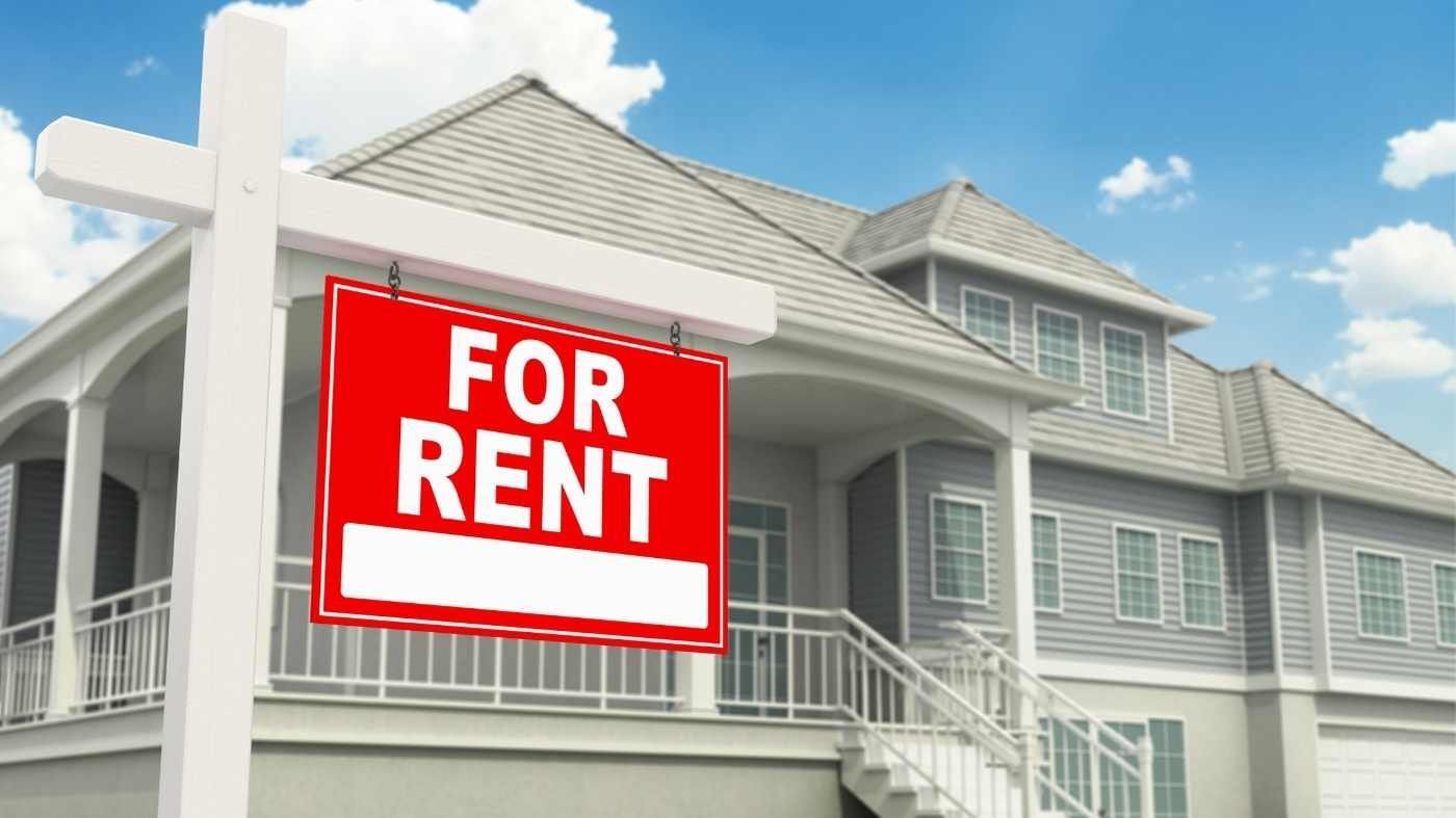 a red home for rent sign