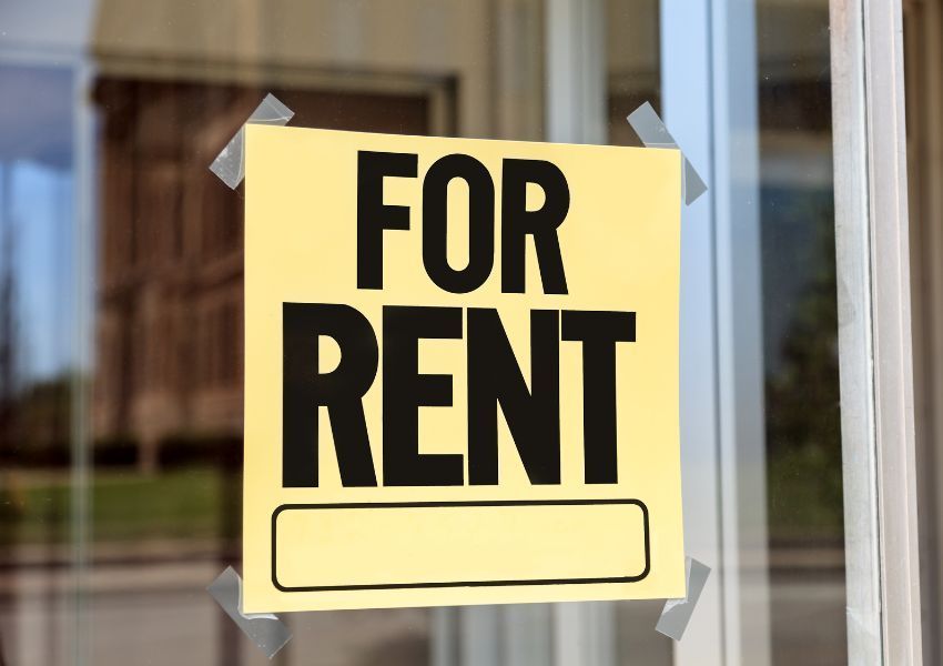 a yellow for rent sign taped in a window