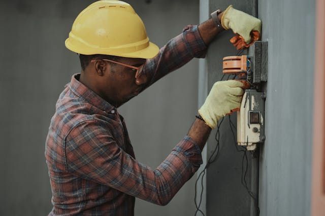 an electrician wearing a hardhat and gloves