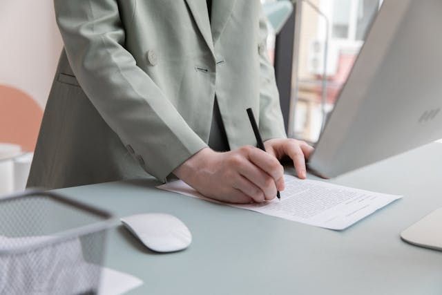 person in a green suit working on a contract