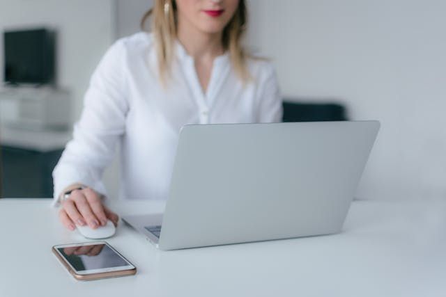 person working on their computer at a white desk