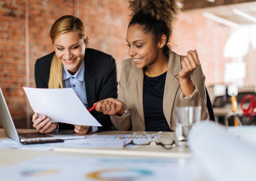 two property managers sitting at a desk looking over documents