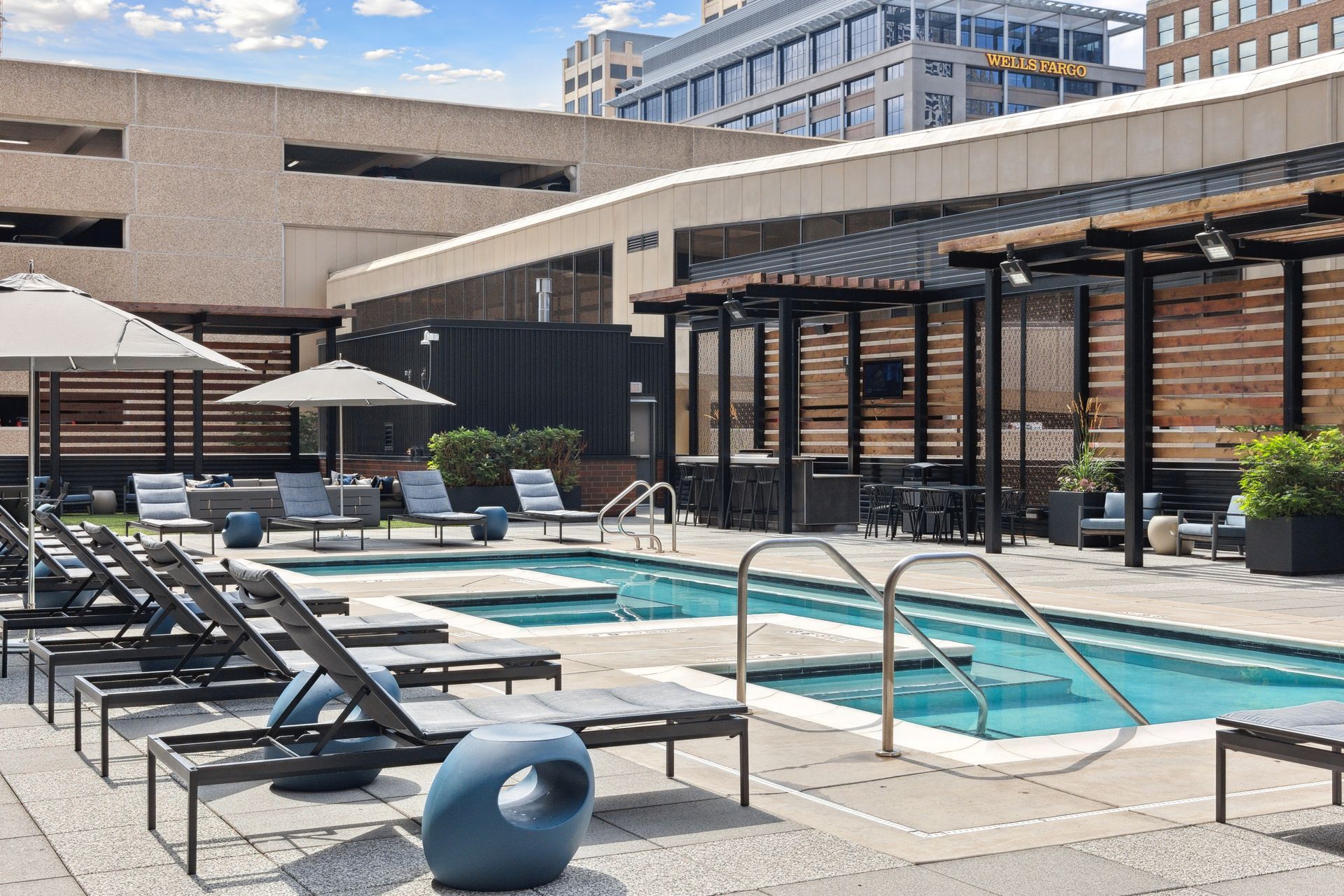 Poolside patio with lounge chairs, small pools, and shaded seating.