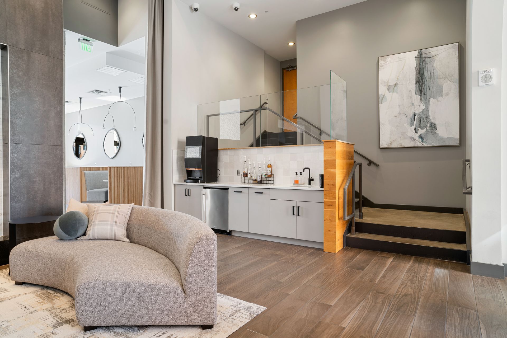 Bright bedroom with a neatly made bed, wall lamps, and a large window overlooking nearby buildings