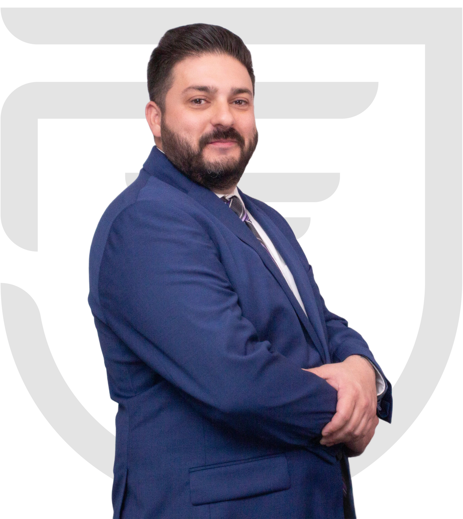 Daniel De Liguori in a blue suit and tie, arms crossed, smiling.