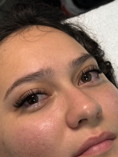 Close-up of a person's face with long eyelashes and light eyebrows.