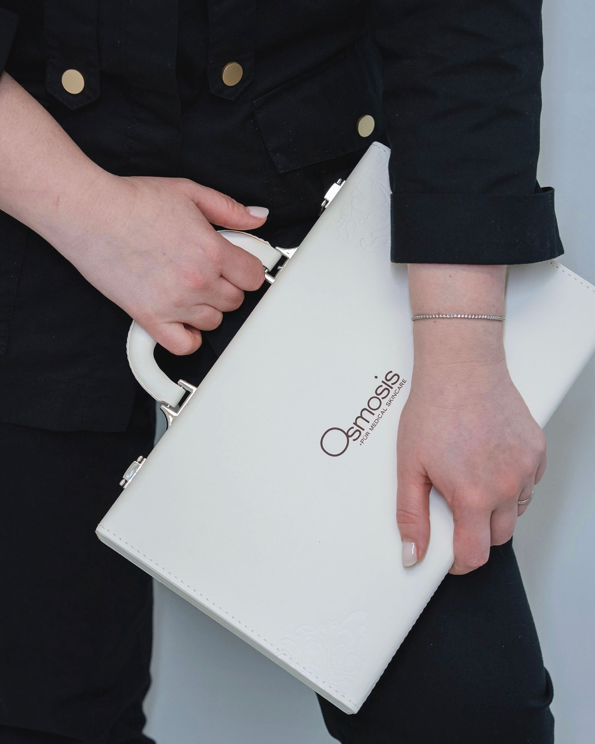 Person holding a white briefcase with the name 