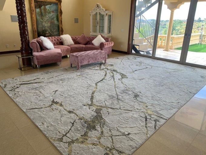 Living room with pink sofa, bench, and marble-patterned rug.