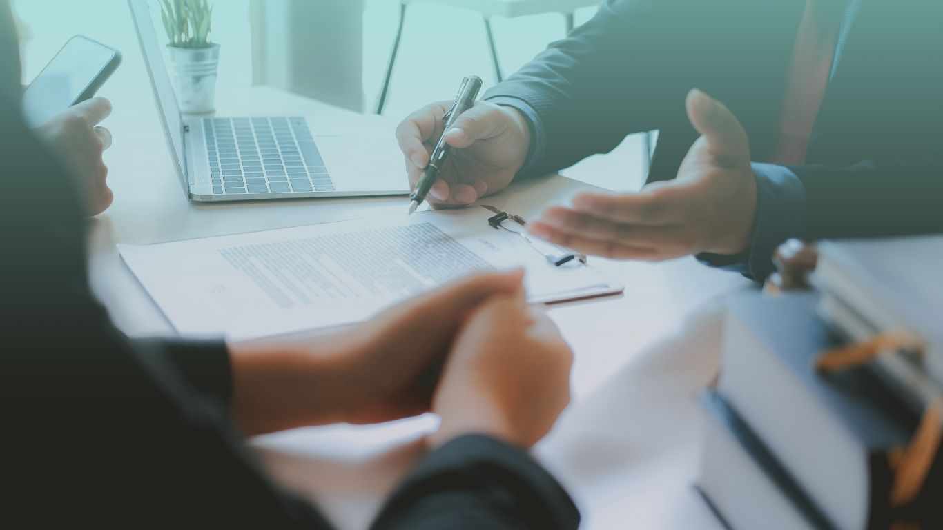 Tax consultant holding financial documents with a real estate investor client, representing tax consulting services.