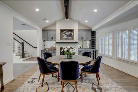 A dining room with a round table and chairs and a fireplace