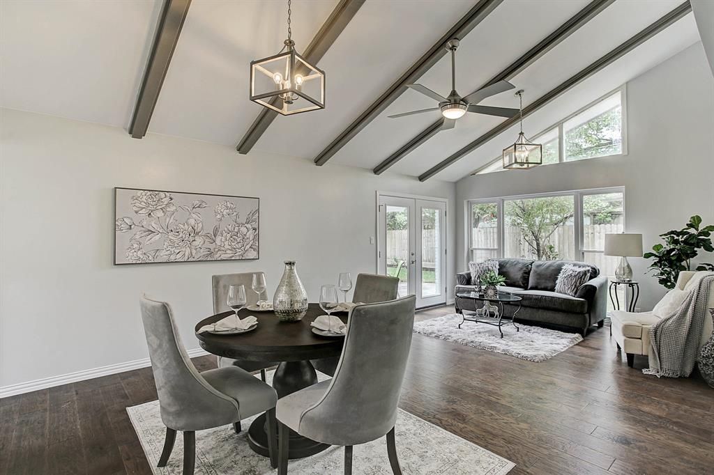 A living room with a dining table and chairs and a ceiling fan
