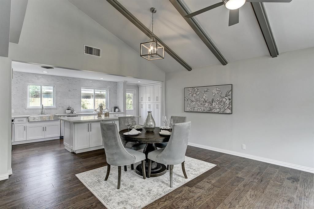 A dining room with a table and chairs and a ceiling fan