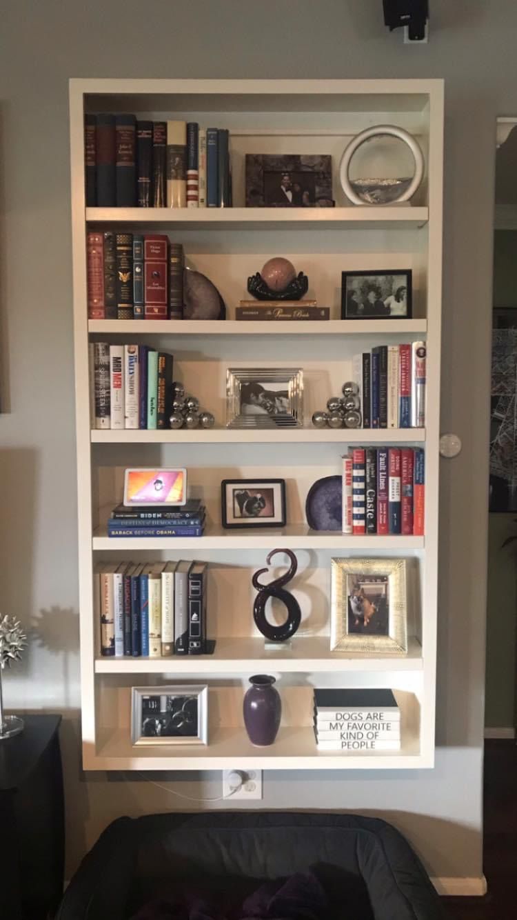 A living room with a bookshelf filled with books and pictures