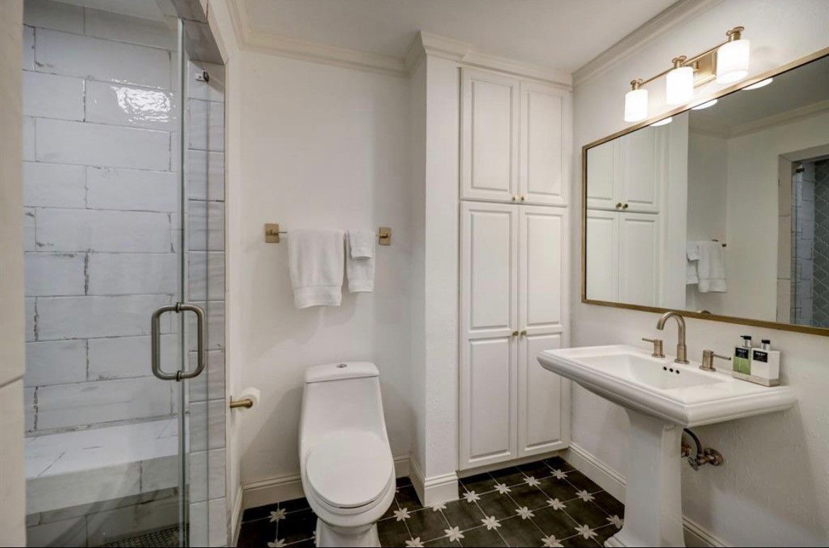 A bathroom with a toilet , sink , and shower