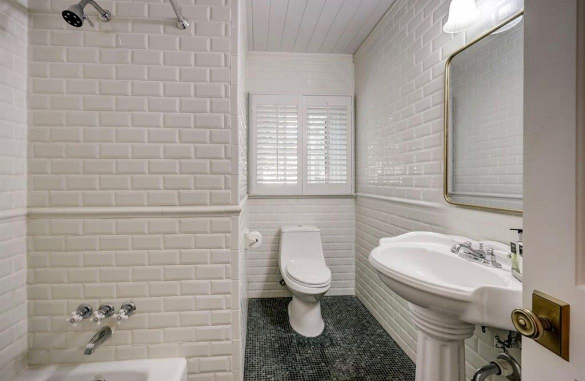 A bathroom with a toilet , sink , and shower