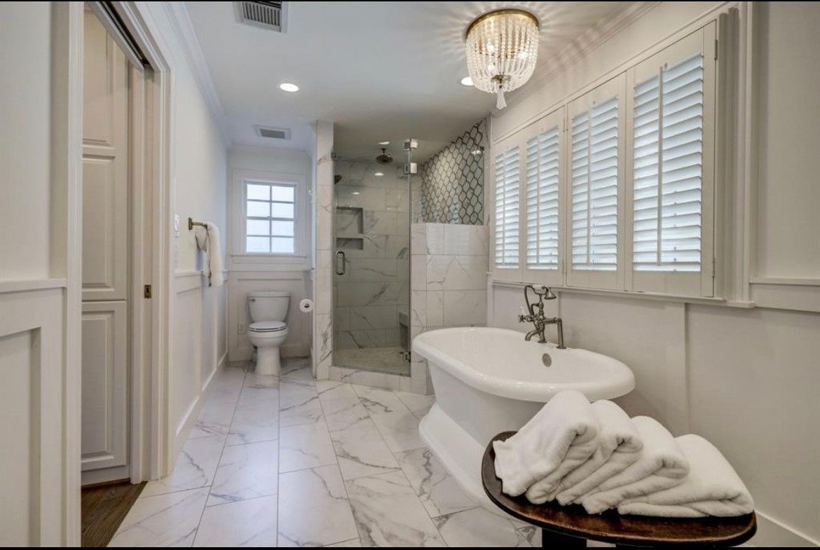 A bathroom with a tub , toilet , and shower