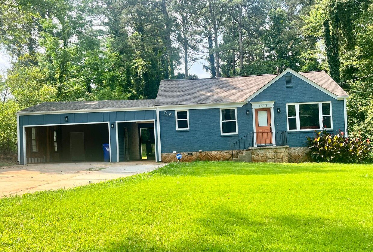 Blue house with a garage, brown roof, and green lawn.