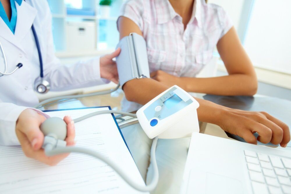 Doctor Taking a Patient's Blood Pressure in a Medical Office — Tewantin Medical Centre In Tewantin, QLD
