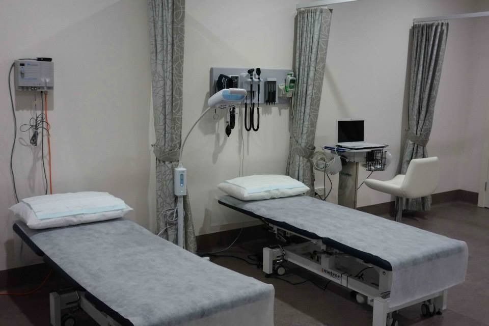 Two Exam Tables in a Medical Room, With Medical Equipment on the Wall, a Laptop — Tewantin Medical Centre In Tewantin, QLD