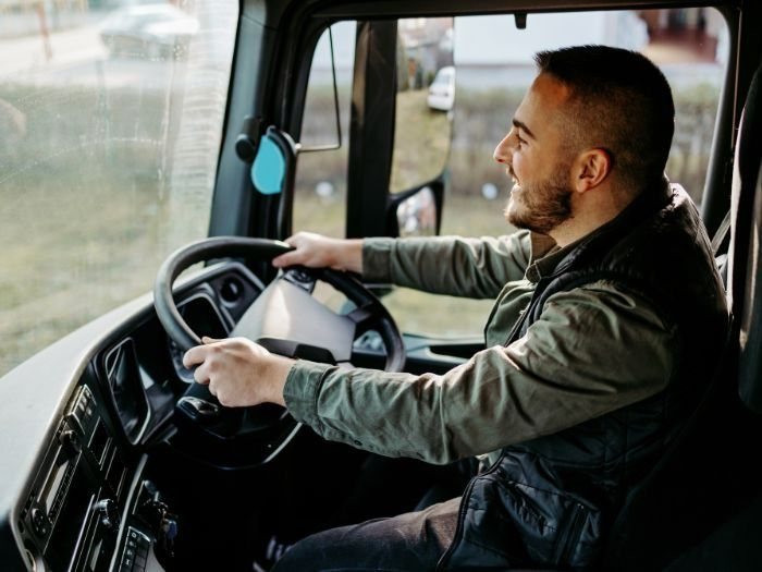 Man Driving a Truck, Smiling, Holding the Steering Wheel — Tewantin Medical Centre In Tewantin, QLD