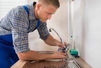 A Plumber Fixing a Faucet