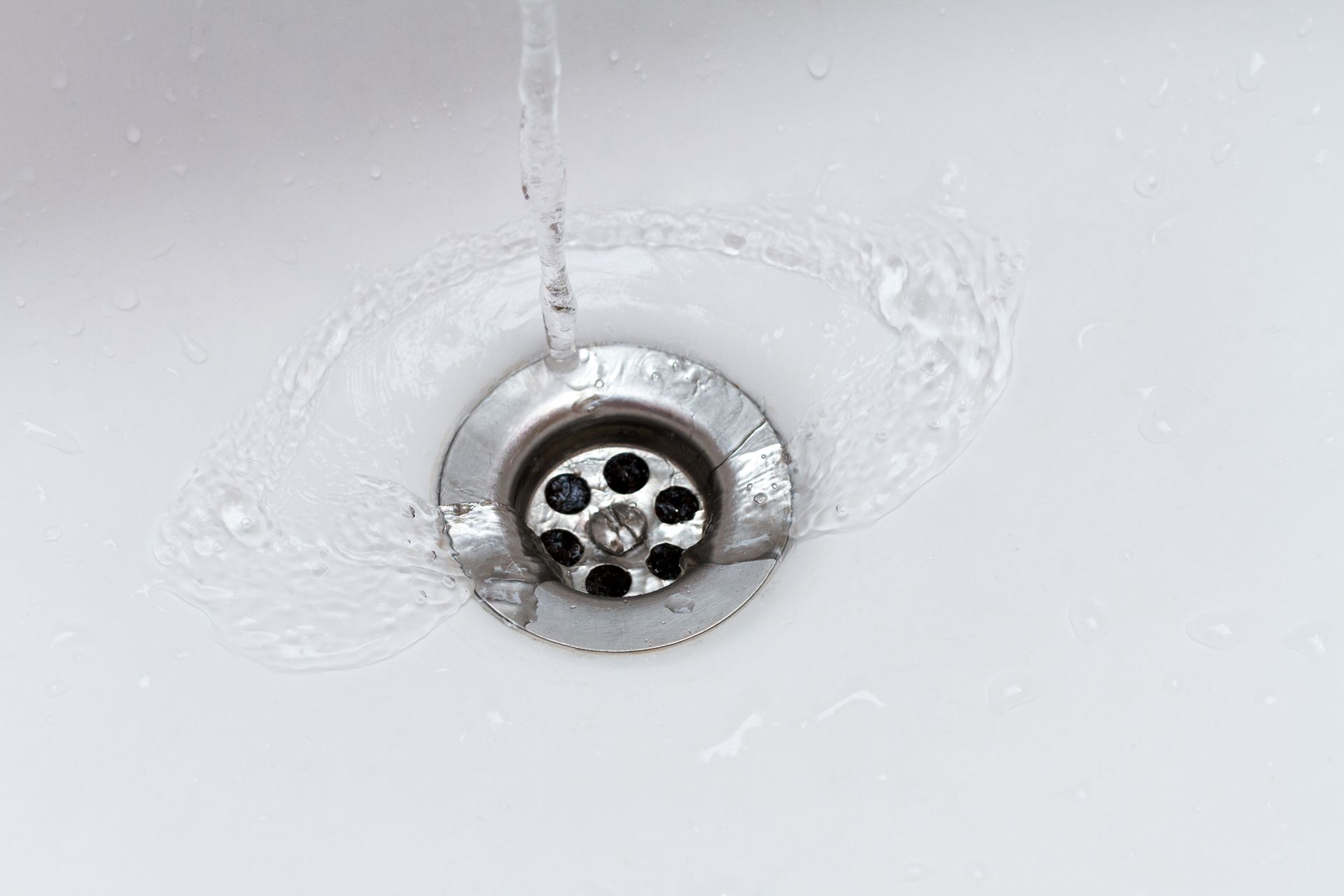 Water is running down a sink drain.