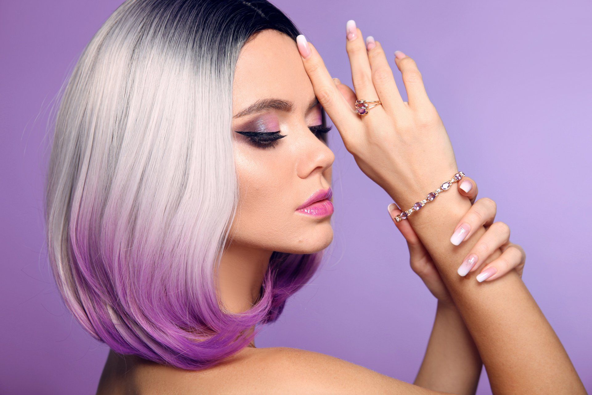 A woman with purple hair and a bracelet on her wrist.