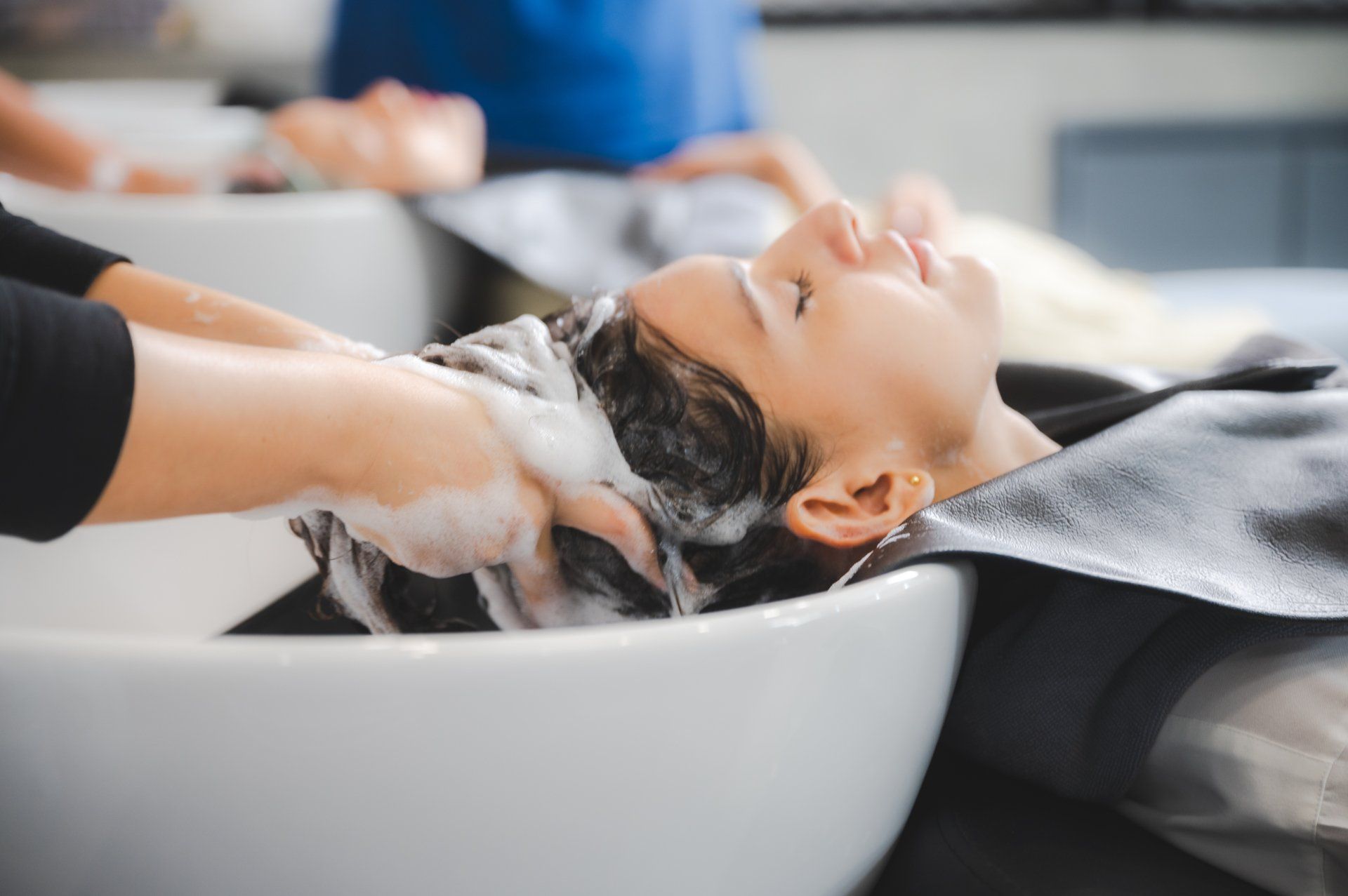 A woman is getting her hair washed in a salon.