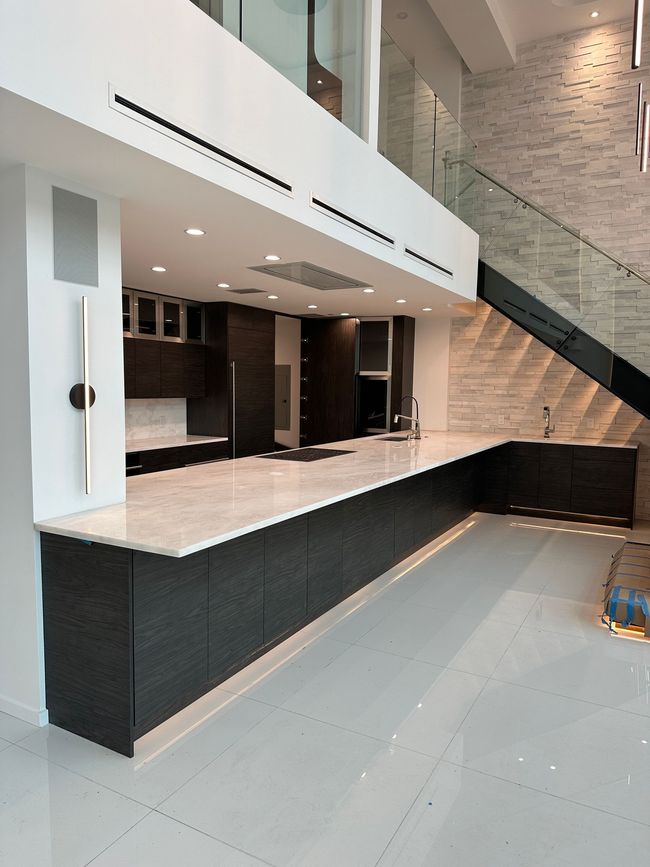 A kitchen with a staircase leading up to the second floor