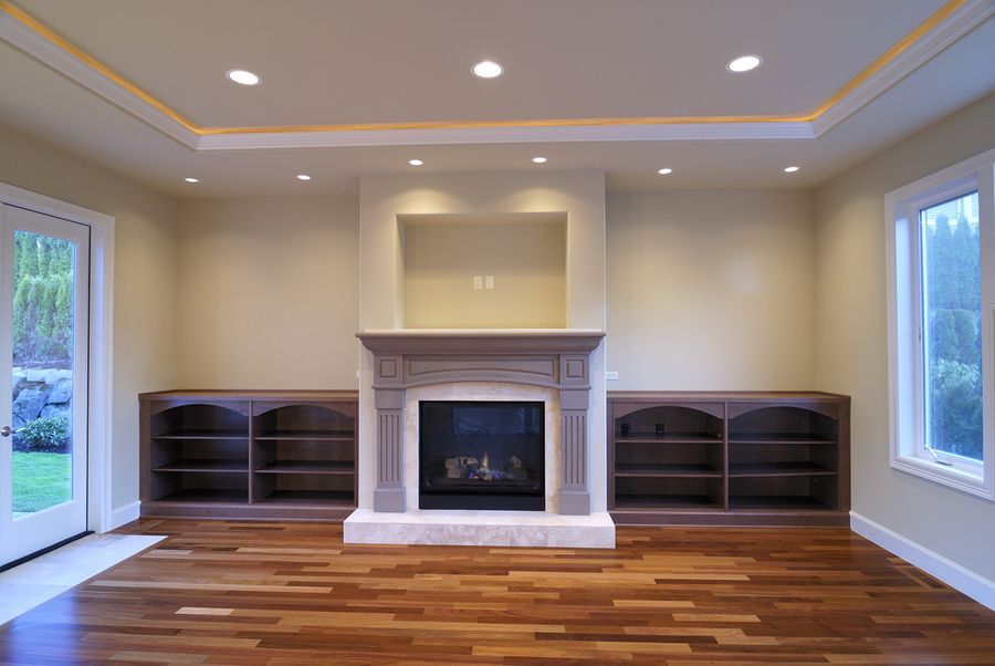 An empty living room with hardwood floors and a fireplace.