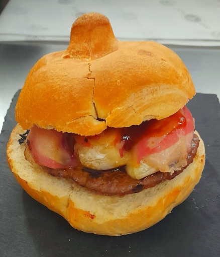 Hamburger in un panino, con polpetta, formaggio e fette di pomodoro.