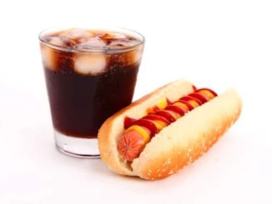 Hot dog con ketchup e senape, accanto a un bicchiere di cola con ghiaccio.