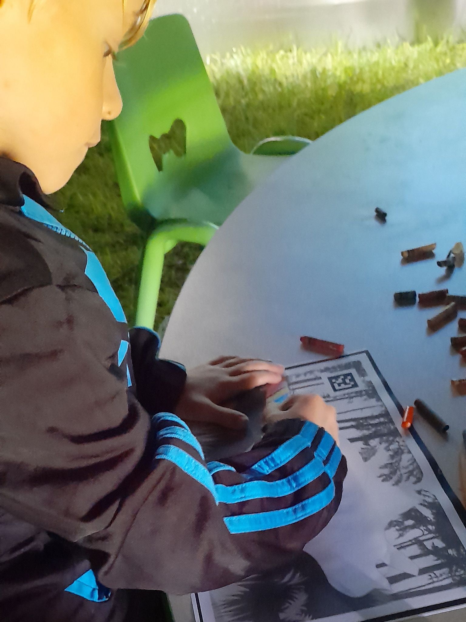 A young boy is sitting at a table with a picture on it