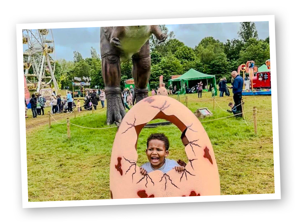 A group of people are standing in front of a large inflatable dinosaur.