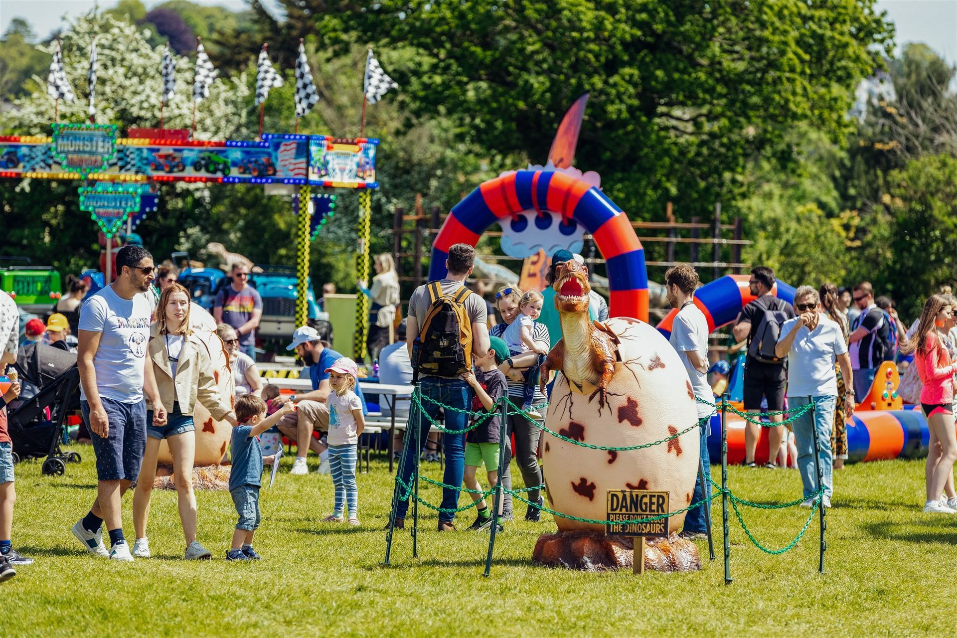 A group of people are standing around a large inflatable cow in a park.