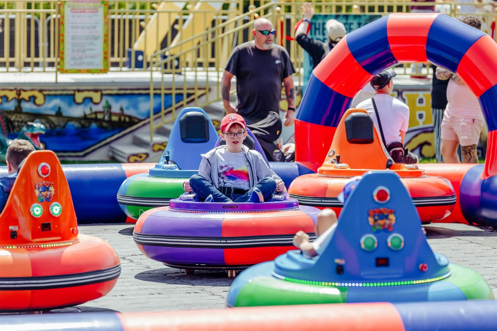 A group of people are riding bumper cars at an amusement park.