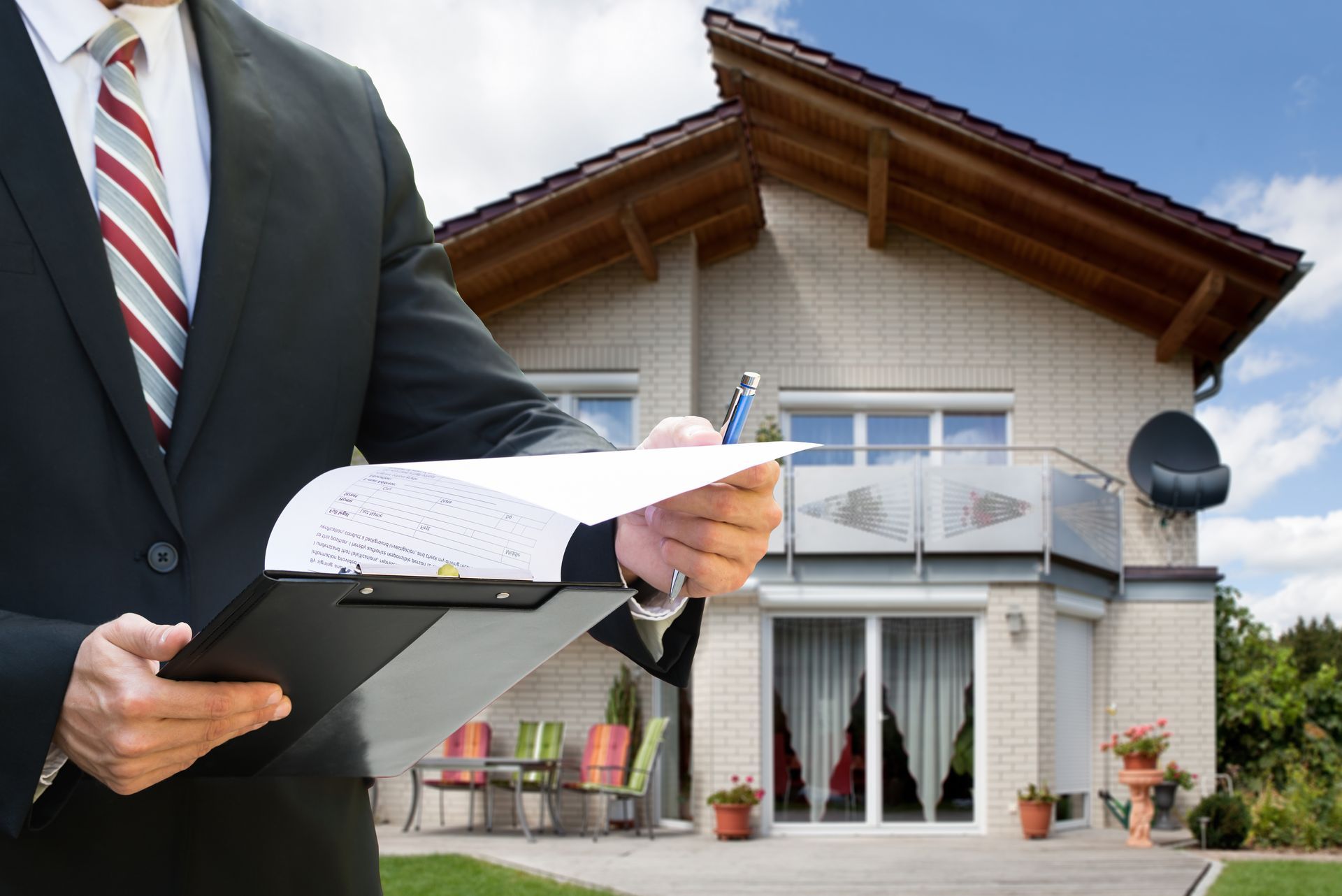 midsection of a man checking documents standing near the house