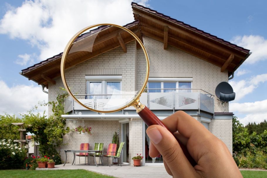 house at the background and magnifying glass
