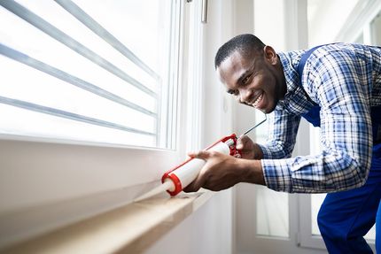 man putting adhesive on the sidings