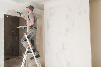 male worker doing drywall plastering