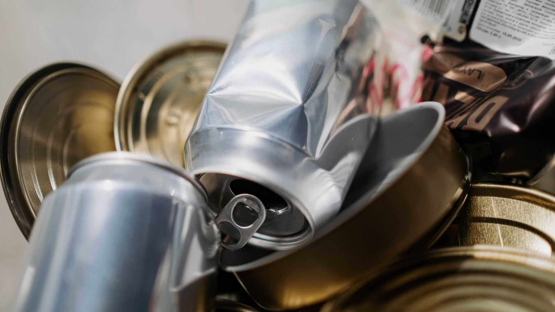 A pile of cans and a plastic bag are stacked on top of each other.