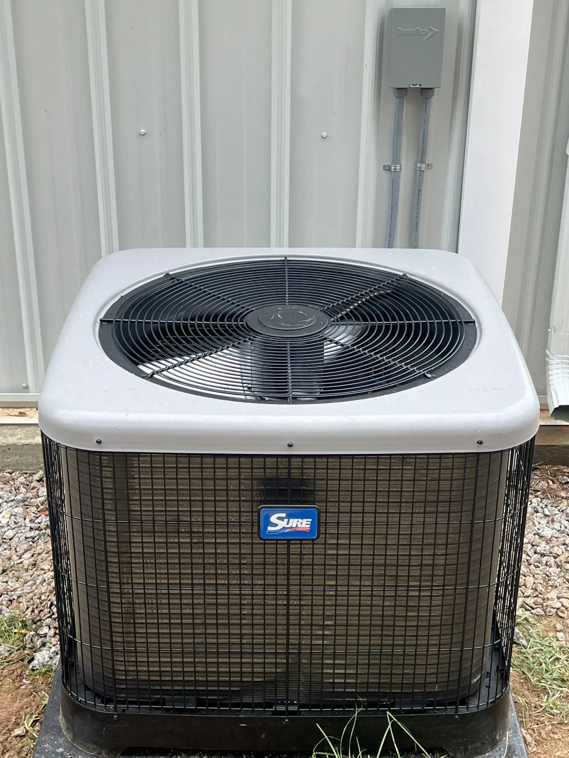 A large air conditioner is sitting outside of a building.