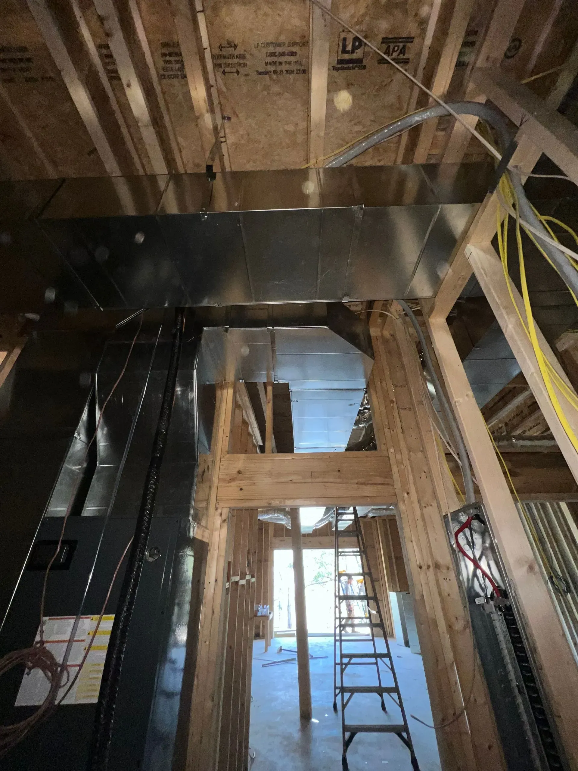 A ladder is hanging from the ceiling of a building under construction.